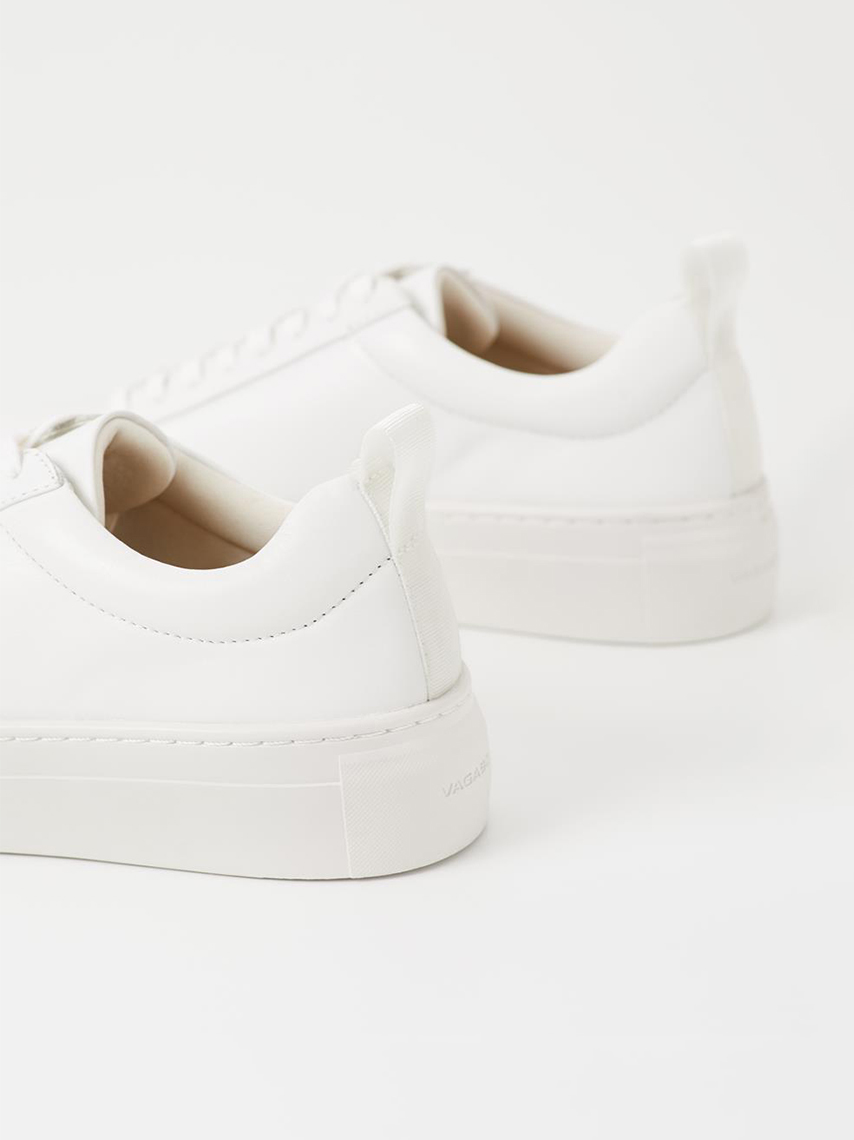 Details of all-white Zoe platform sneakers, with their chunky outsoles and heel loop tabs.