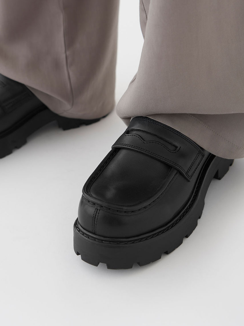 En detaljvy av Cosmo 2.0 loafers, i bordeaux-färgat skinn, med tofsar och fransdetaljer