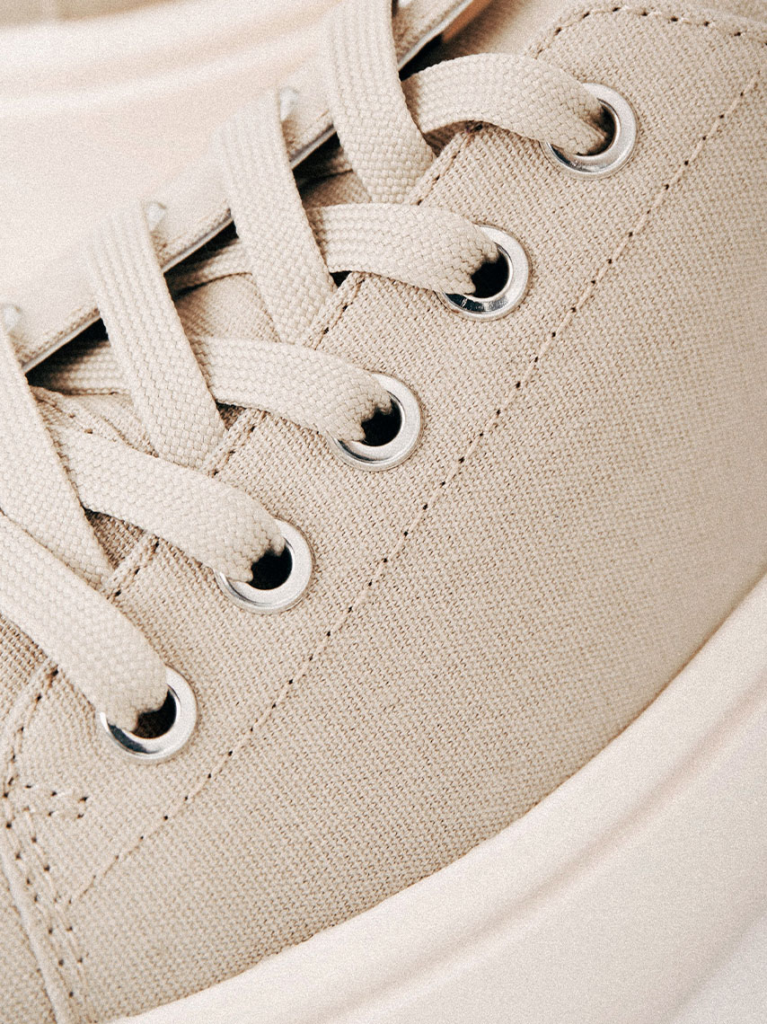 Laced textile shoe in beige canvas.