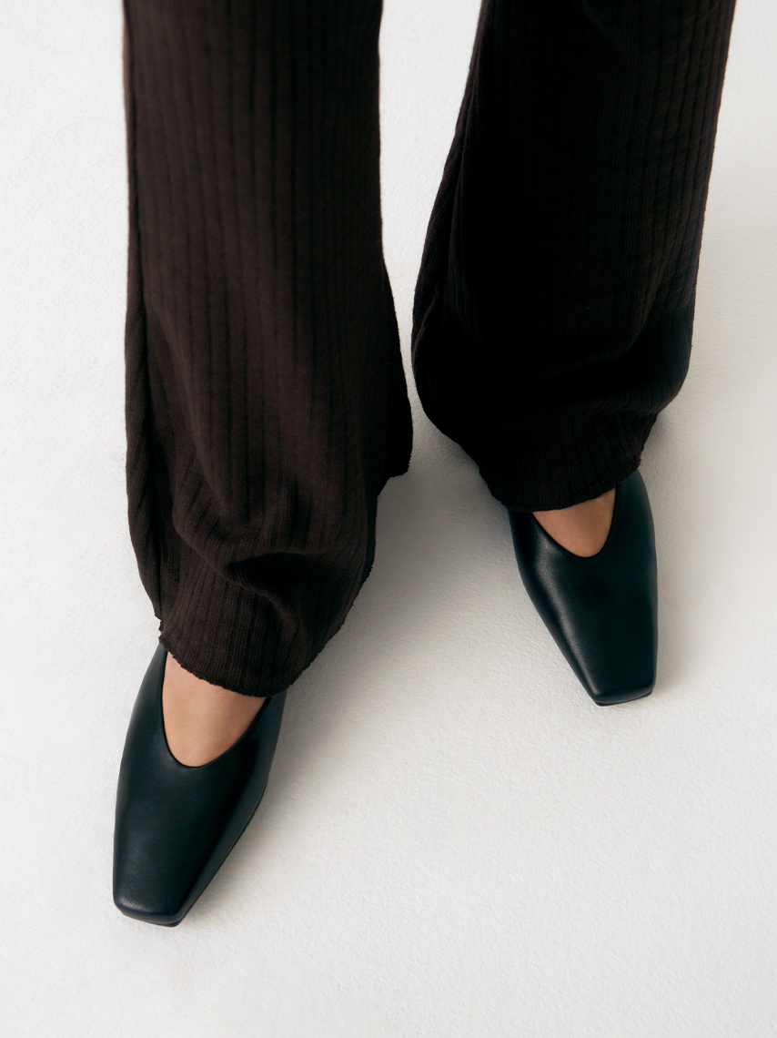 The pointy ballet flats Wioletta in black leather with square toe styled with black, wide trousers