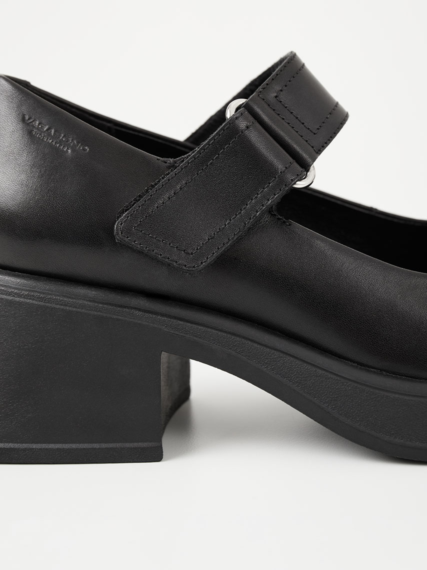 Scarpe Mary Jane Cosmo 2.0 in pelle nera, abbinate a calzini bianchi a coste e pantaloni neri.