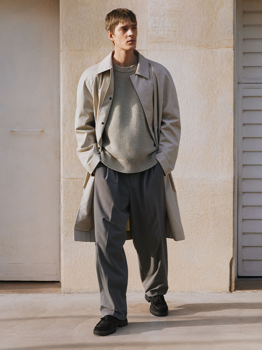 The model wearing grey attire in an oversize fit, and Johnny 2.0 loafers in black suede.
